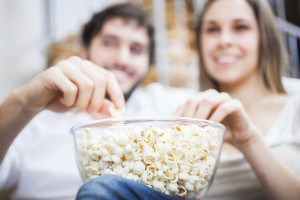 Couple eating popcorn while watching a movie