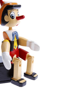 Wooden pinocchio on plain background