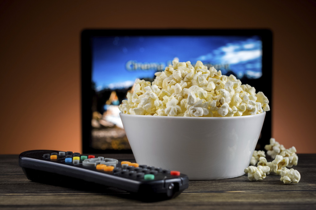 Popcorn and a remote control for the TV background