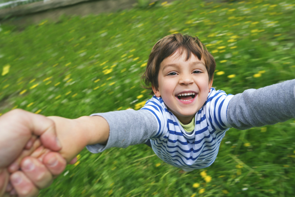 Cute boy laughing being spun around