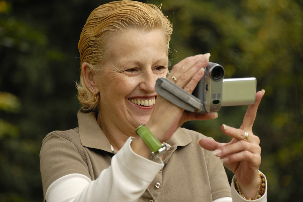 middle-aged woman filming with a handycam