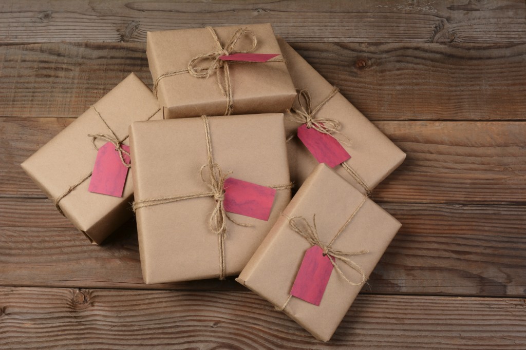 A pileof eco friendly wrapped Christmas Presents, on a rustic wood background.