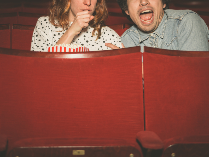 Couple watching a scary film in a movie theater