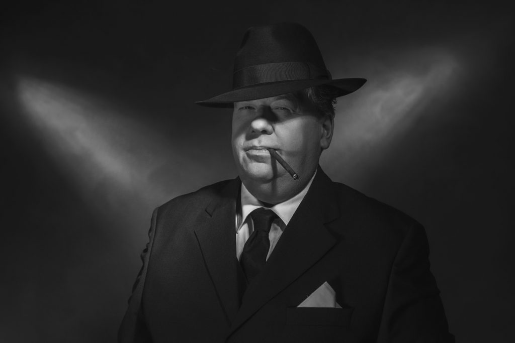 Retro 1930s gangster smoking cigar. Classic black and white portrait.