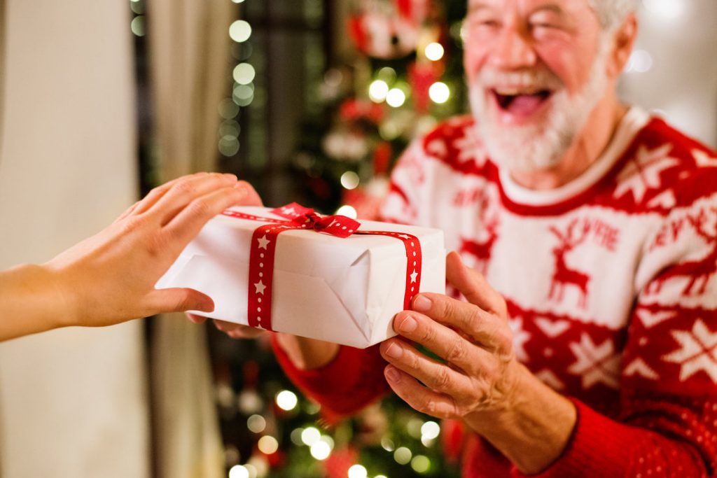 Delighted Elderly Man Receiving a Christmas Gift