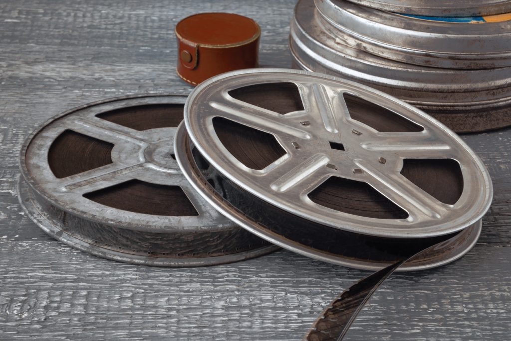 Reels with old film and tin boxes lie on a wooden table